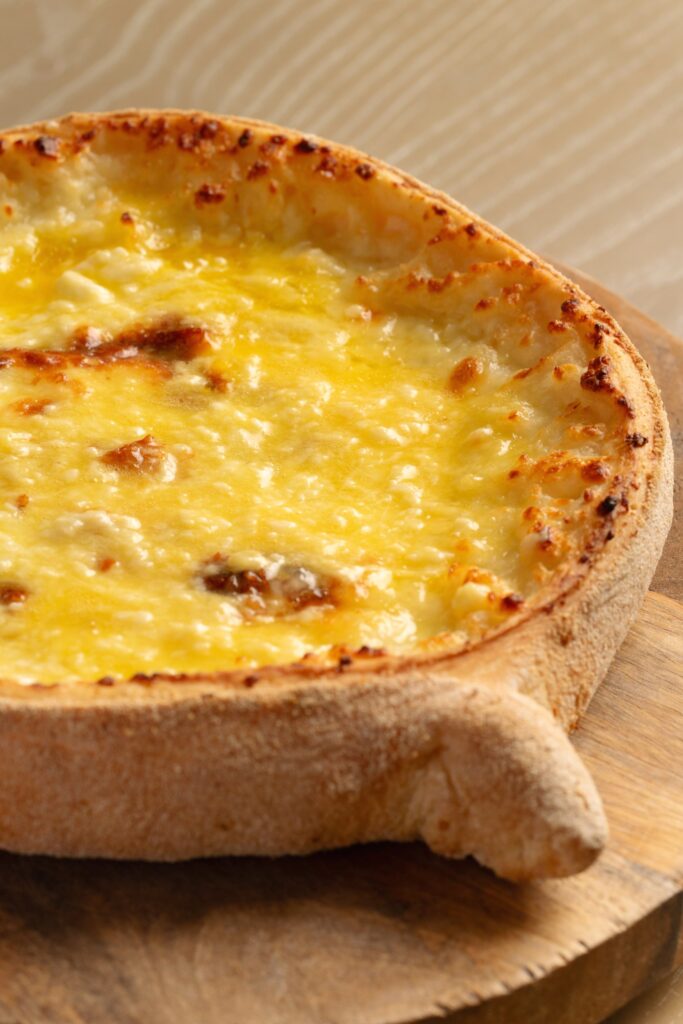 Close-up of the baked crust and melted cheese of Adjarian khachapuri