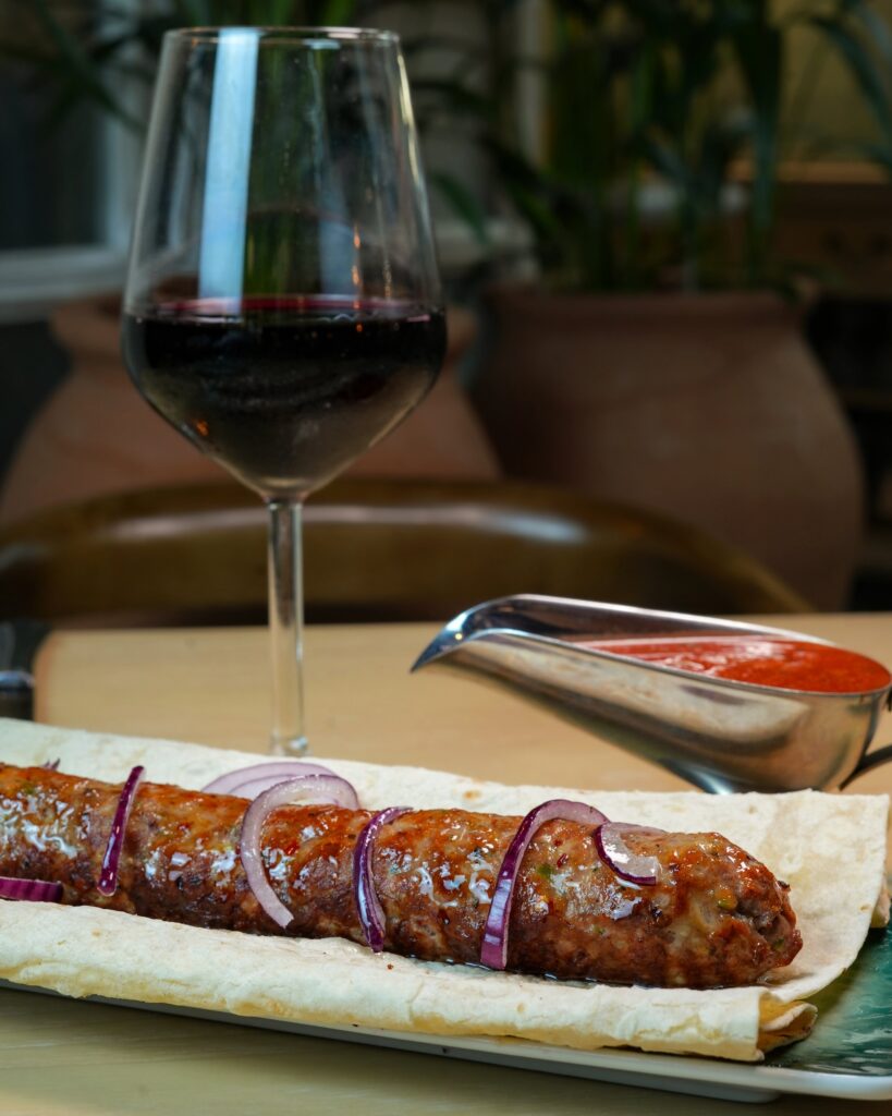 Kebab on lavash beside a glass of red wine, Vakhtanguri restaurant